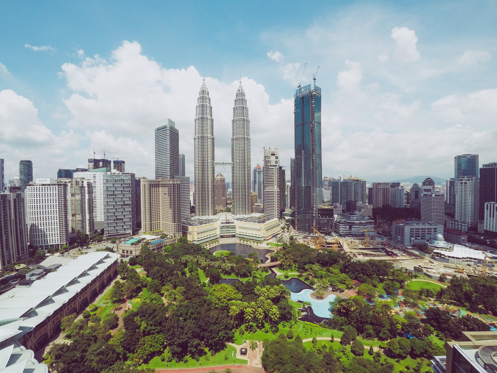 petronas-twin-towers-near-skyscrapers-trees-blue-sky-kuala-lumpur-malaysia-min Image